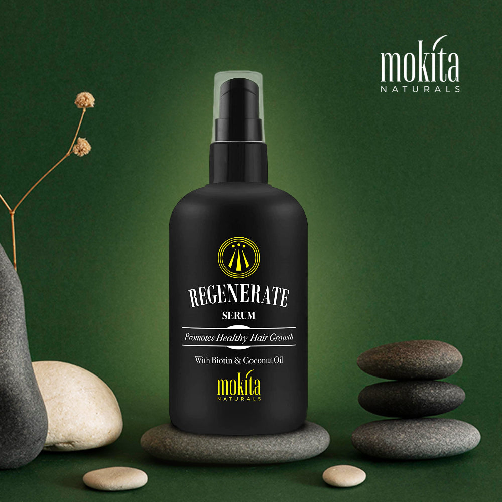 Black serum bottle labeled 'Regenerate Serum' by mokita on a green background with stones and a plant.
